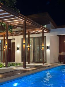 a swimming pool in front of a house at night at Balay Vicente in Tarlac