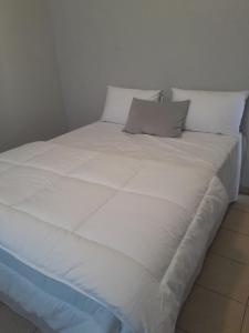 a large bed with white sheets and pillows at Shalom Villa Guesthouse Walvis in Walvis Bay +16 photos