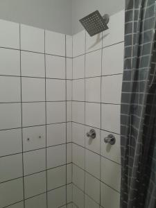a white tiled shower with a shower curtain at Shalom Villa Guesthouse Walvis in Walvis Bay