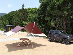 une camionnette avec une tente et une table dans l'établissement Nagai Peony Forest Campsite - Vacation STAY 27777v, à Yamagiwa 1 autre photo
