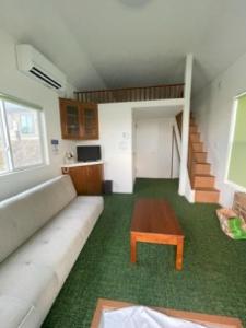 un salon avec un canapé et une table basse dans l'établissement Nagai Peony Forest Campsite - Vacation STAY 27777v, à Yamagiwa