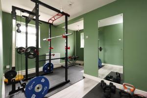 Un gimnasio con paredes verdes y un espejo. en Perfect Bridgend Stay: Comfort & Space!, en Bridgend