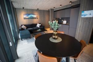 a living room with a table and a couch at Opplev nordlyset og bo ved sjøkanten! in Henningsvær