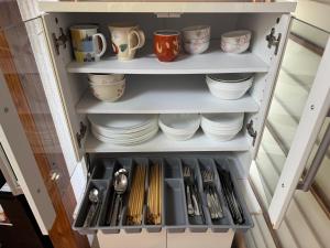 ein Schrank voller Teller und Besteck in der Unterkunft Polar Resort Nikko 4 - Vacation STAY 30491v in Nikko + 14 Fotos