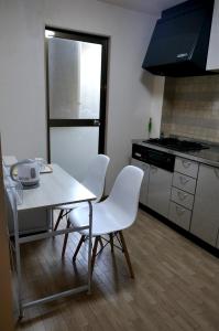 a kitchen with a table and chairs and a stove at Minpaku =SAKURA= - Vacation STAY 16462 in Osaka +6 photos
