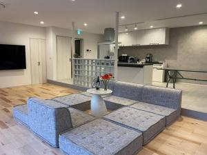 a living room with a blue couch and a table at staydio no-name - Vacation STAY 16481 in Kamogawa