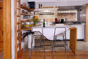 a kitchen with a white table and stools at Haus Marta in Elmstein