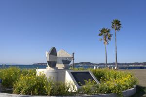 Un monumento en la playa con flores y palmeras. en RE:VER Hojo - Vacation STAY 37337v, en Tateyama
