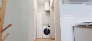 a white laundry room with a washer and dryer at Guadalimar in Seville +1 photo