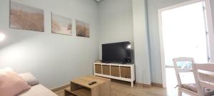 a living room with a couch and a tv at Guadalimar in Seville