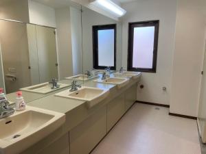 a bathroom with three sinks and two mirrors at GONZOU-HOUSE - Vacation STAY 42967v in Zao
