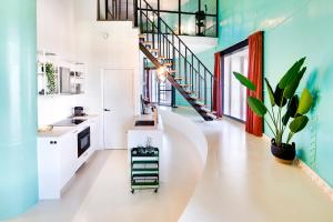 a kitchen with white cabinets and blue walls at Hotel Watertoren West in Groningen