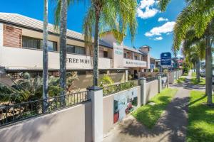 uma rua em frente a um hotel com palmeiras em Cairns City Palms em Cairns