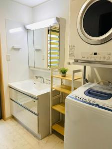 a small kitchen with a sink and a washing machine at emma green - Vacation STAY 55704v in Sesoko