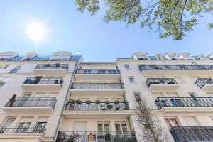 a building with balconies and the sun in the sky at Superbe appartement pour 6P aux portes de Paris in Saint-Maurice
