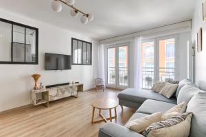 a living room with a couch and a tv at Superbe appartement pour 6P aux portes de Paris in Saint-Maurice