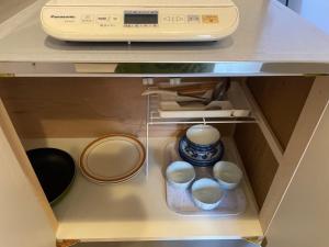a drawer of a cabinet with eggs and a microwave at Chambord Kyomachi 102, 201, 202, 205, 207 - Vacation STAY 44168v in Kumamoto