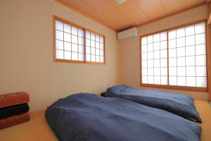 zwei Betten in einem Zimmer mit zwei Fenstern in der Unterkunft Garden House Kujukuri - Vacation STAY 44383v in Mobara
