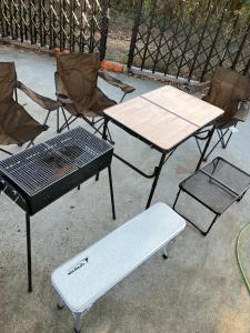 ein Tisch und Stühle sowie ein Picknicktisch und eine Bank in der Unterkunft Garden House Kujukuri - Vacation STAY 44383v in Mobara