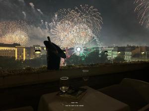 a table with a wine glass and fireworks in the background at Vista Suites 1-2 in Budapest
