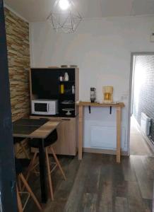 una piccola cucina con un tavolo e un microonde di Appartement avec terrasse 100m plage a Berck-sur-Mer