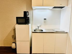 La cocina está equipada con fregadero, microondas y nevera. en Zennichi - Vacation STAY 15750v, en Kioto