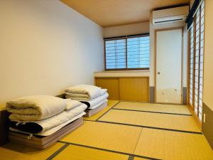 Dos camas en una habitación con suelo amarillo y una ventana. en Zennichi - Vacation STAY 15750v, en Kioto