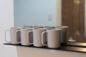 una fila de tazas de café blancas sentadas en un estante en Zennichi - Vacation STAY 60323v, en Kioto