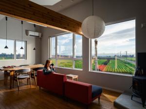 a woman sitting on a couch in a room with a view of a vineyard at Buena Vista Tokachi - Vacation STAY 47319v in Obihiro