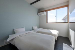 two beds in a small room with a window at Kujukuri point 59 - Vacation STAY 49312v in Kujukuri
