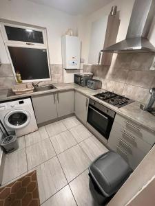 a kitchen with a stove and a sink and a microwave at Contractor home close to centre and motorway links in Liverpool