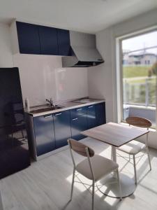 a kitchen with blue cabinets and a table and chairs at Guesthouse Senba - Vacation STAY 16607 in Mito