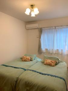 two beds in a room with a window at Calm Enoshima 102 - Vacation STAY 61941v in Kamakura