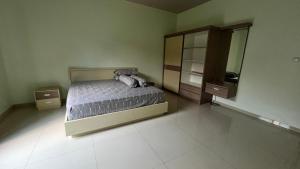 a bedroom with a bed and a dresser and a mirror at The Villa Nirvana Tawangmangu in Tawangmangu