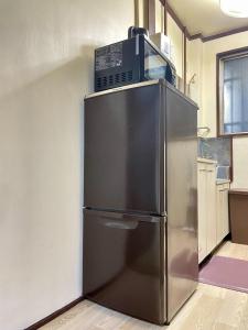 a stainless steel refrigerator with a box on top of it at Shobi Building 2 208 - Vacation STAY 16685 in Tokyo