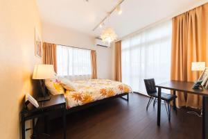 a bedroom with a bed and a desk and a desk at Gajumaru no niwa - Itoman - Vacation STAY 16759 in Itoman
