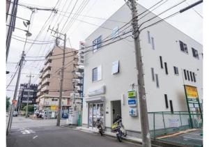 twee personen op motorfietsen geparkeerd voor een gebouw bij Travel Palace Miyuki - Vacation STAY 16820 in Kawaguchi