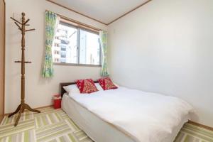a bedroom with a bed with red pillows on it at Travel Palace Miyuki - Vacation STAY 16822 in Kawaguchi