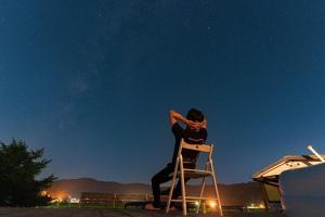 a woman sitting on a chair at night at BlueBear Higashino - Vacation STAY 83656v in Nagahama