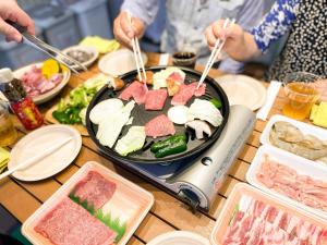 a table topped with a grill with meat and vegetables at Airy Peak - Vacation STAY 82764v in Takaharu