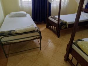 ein Zimmer mit zwei Etagenbetten und Fliesenboden in der Unterkunft Elisol House in Mombasa