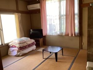 a room with a bed and a table and a tv at Strawberry Villa - Vacation STAY 18551 in Ichihara +24 photos
