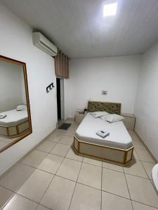 a room with a bed and a mirror in it at Hotel bom retiro in Sao Paulo