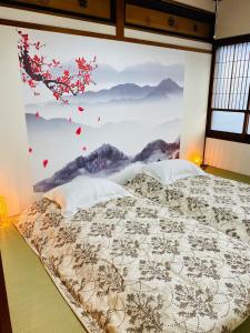 a bedroom with a large painting on the wall at Karin Housu - Vacation STAY 82851v in Takayama +11 photos