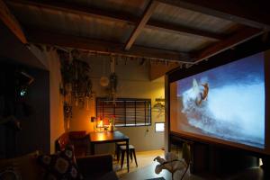 a living room with a large flat screen tv at Hinata Surf Camp 108,110 - Vacation STAY 84402v in Hyuga