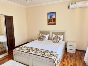 a bedroom with a bed with white sheets and pillows at Feruza guest house in Samarkand +21 photos