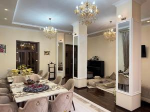a dining room and living room with a table and chairs at Feruza guest house in Samarkand