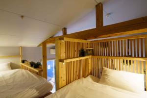two beds in a room with wooden walls at Hinata Surf Camp 103 - Vacation STAY 88437v in Hyuga