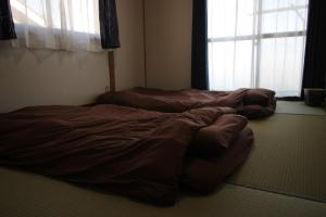 two unmade beds in a room with a window at Fukutokukashiya - Vacation STAY 16907 in Kagoshima