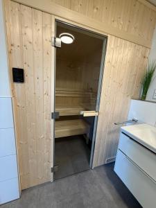 a bathroom with a shower and a door to a tub at Penthouse-Ferienwohnung "Tom" in Butjadingen